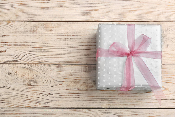 Elegant gift box with bow on wooden background, top view - Photo, Image
