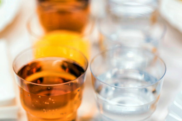 Plastic glasses with drinks on banquet table - Φωτογραφία, εικόνα