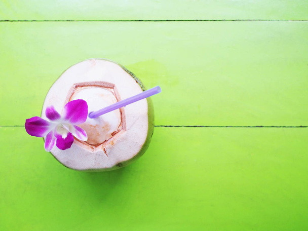 Coconut drinking juice on green table - Photo, Image
