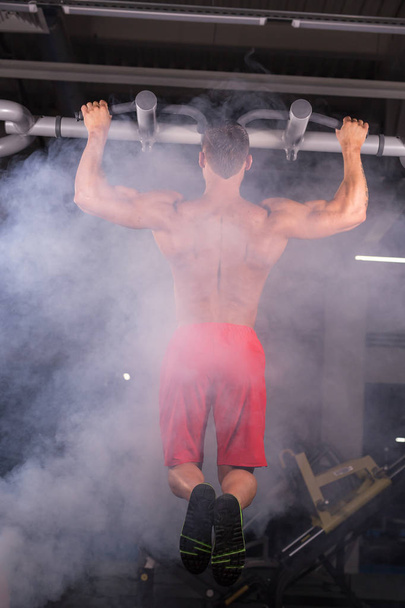Bonito homem muscular com corpo perfeito fazendo puxar Ups no ginásio
 - Foto, Imagem