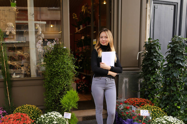 Directrice de magasin de fleurs debout avec des papiers
. - Photo, image