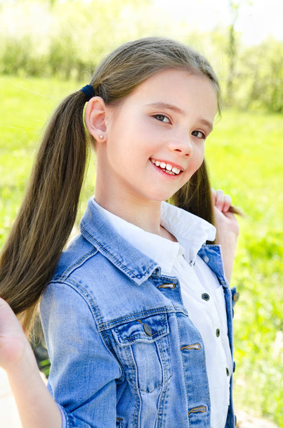 Portrait of adorable smiling little girl outdoors - 写真・画像