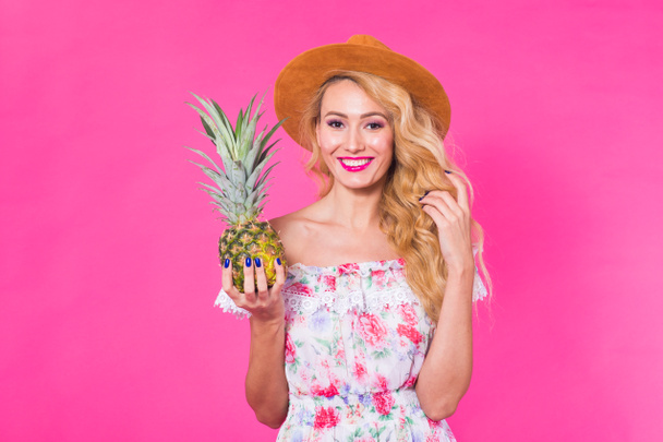 Portrait of happy woman and pineapple over pink background. Summer, diet and healthy lifestyle concept - Photo, Image