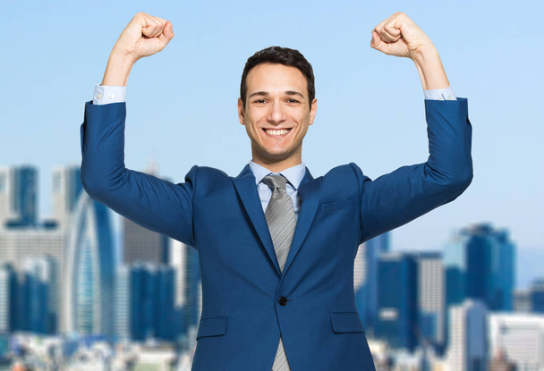 Handsome businessman raising arms in sign of victory - Foto, immagini