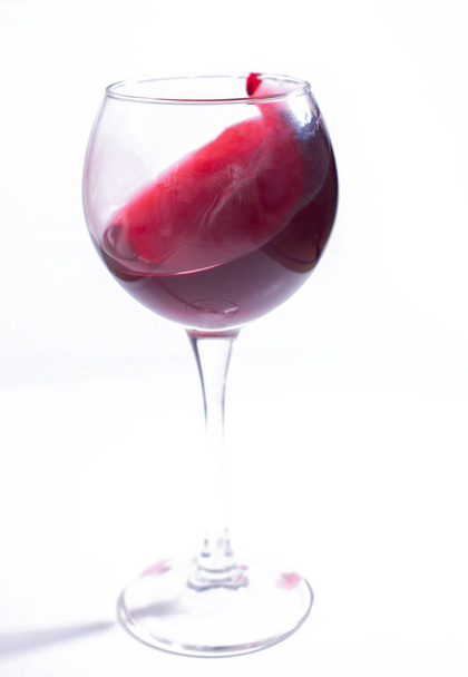 A glass with red wine on a white background. Isolate - Zdjęcie, obraz