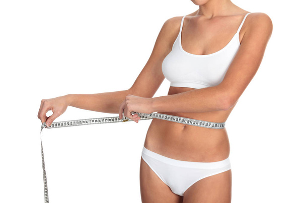 Mulher magra medindo sua cintura, isolada em fundo branco
 - Foto, Imagem