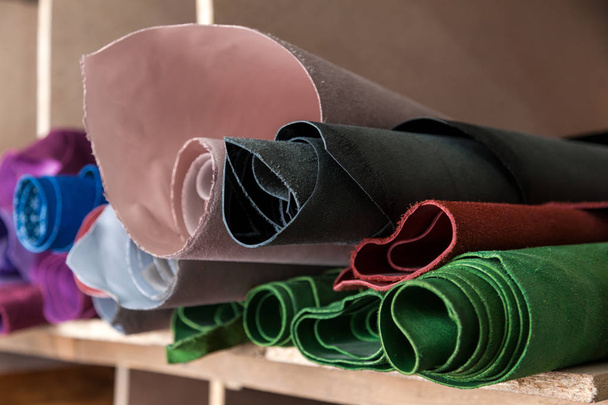 Primer plano de incluso filas de piel natural de rosa, rojo, azul, verde y negro zapatos y chaquetas
 - Foto, Imagen