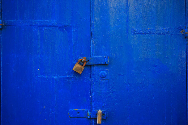 Puinen sininen oven tausta lukittu kahdella ruosteisella riippulukolla. Aged, suljettu sisäänkäynti, lähikuva yksityiskohtia
. - Valokuva, kuva