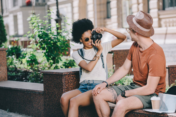 young female traveler taking picture of boyfriend on camera  - Valokuva, kuva