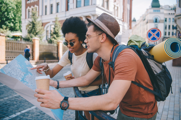 multiethnic couple of young tourists with map and coffee cups  - Photo, Image