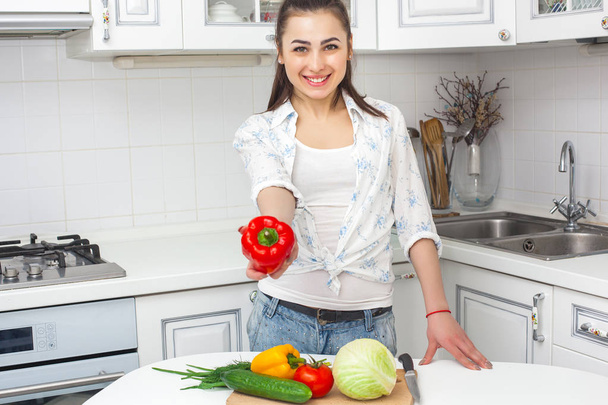 Young attractive woman cooking salad indoors at the kitchen - Photo, image