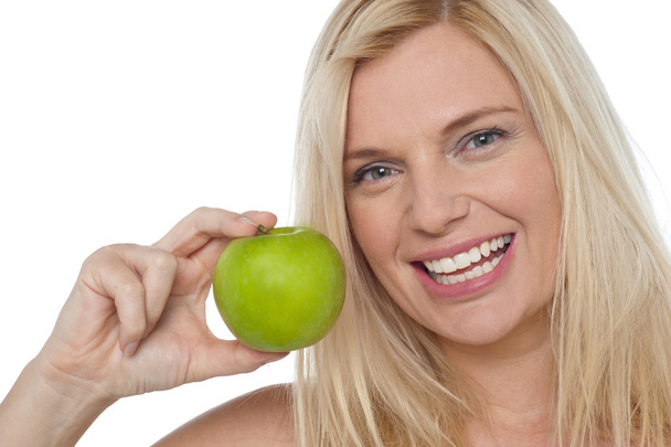 Closeup shot of a cheerful woman holding an apple - Valokuva, kuva
