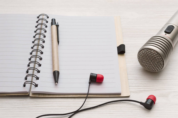 Audio recording studio desk table. Karaoke mock up. Microphone, headphones and blank page notepad with copy space for song lyrics on white table background. - Fotoğraf, Görsel