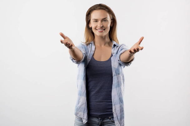 portrait of happy cheerful woman in blue denim shirt pull hands forward - Photo, image