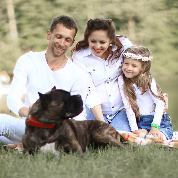 happy family with pet dog at picnic in a Sunny summer day. - Фото, зображення