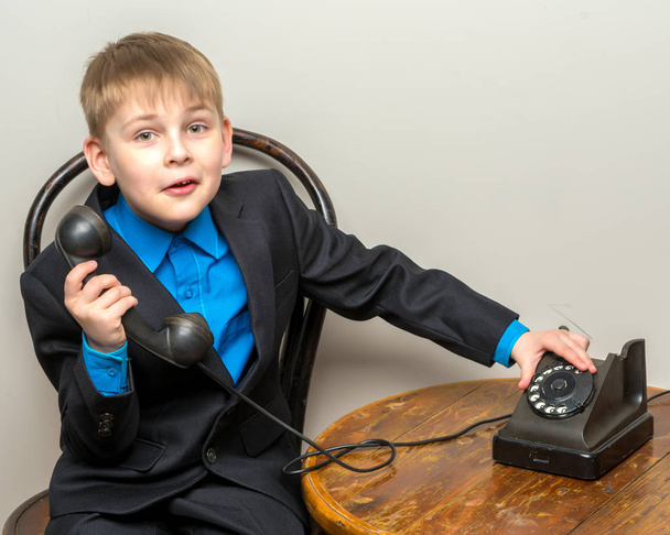 The little boy is ringing the old telephone. - Valokuva, kuva