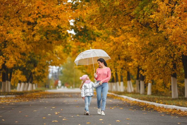 Nuori kaunis äiti pienen tyttärensä kanssa hauskaa syksyllä taustalla. Onnellinen perhe syksyllä
 - Valokuva, kuva
