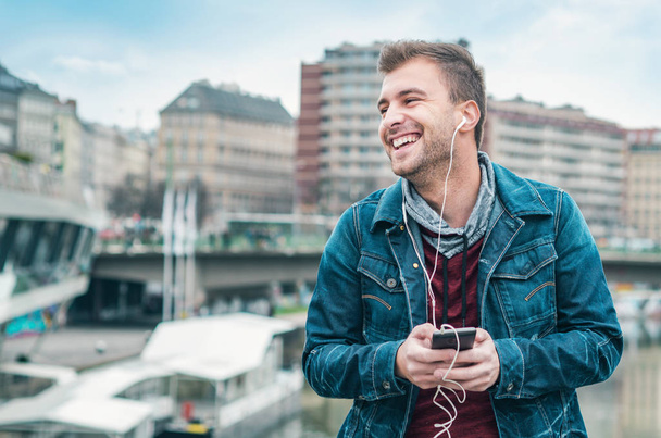 Happy young man listening music enjoying on street - Fotografie, Obrázek