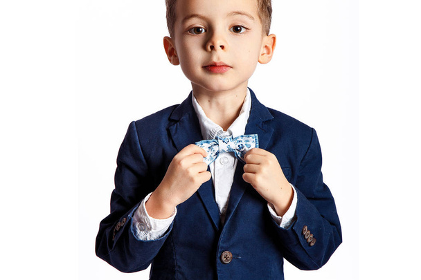 Young boy in suit with bow-tie posing against white background - Foto, immagini
