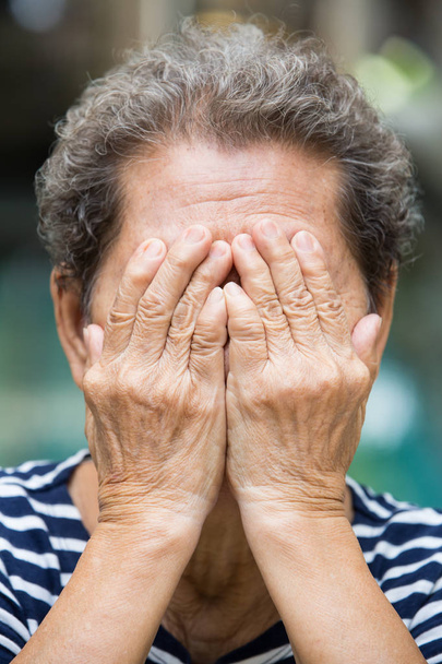 Старшая женщина, скрывающая лицо руками, с закрытыми руками
 - Фото, изображение