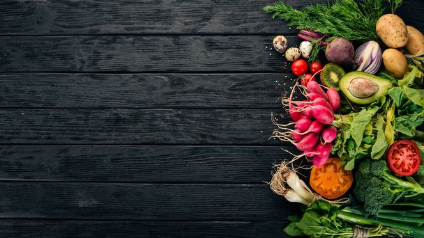 Healthy food. Vegetables and fruits. On a black wooden background. Top view. Copy space. - Photo, Image
