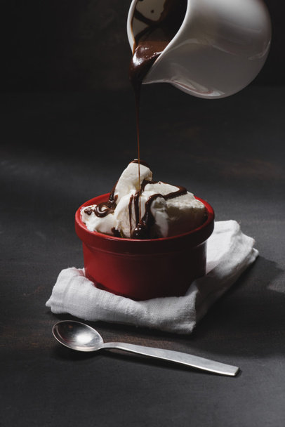delicious ice cream pouring with chocolate in bowl on table - Fotoğraf, Görsel
