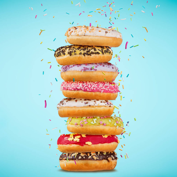 Tasty doughnuts on pastel blue background. - Foto, Imagem