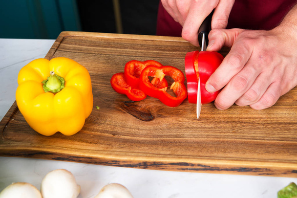 Organic vegetables getting cut on wooden cutting board. Organic products concept - Fotoğraf, Görsel
