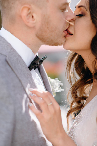 Cropped view of lovely newlyweds kissing in garden - 写真・画像