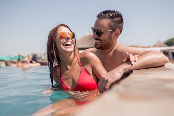 happy young couple relaxing in swimming pool  during vacation - Photo, Image