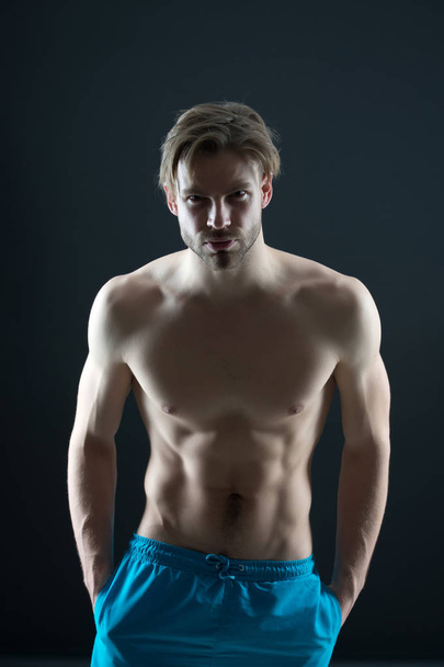 Sport or fitness and bodycare concept. Athlete with fit body in shorts. Man with six pack and ab muscles. Sportsman with sexy torso and chest. Training and workout activity in gym - Foto, afbeelding