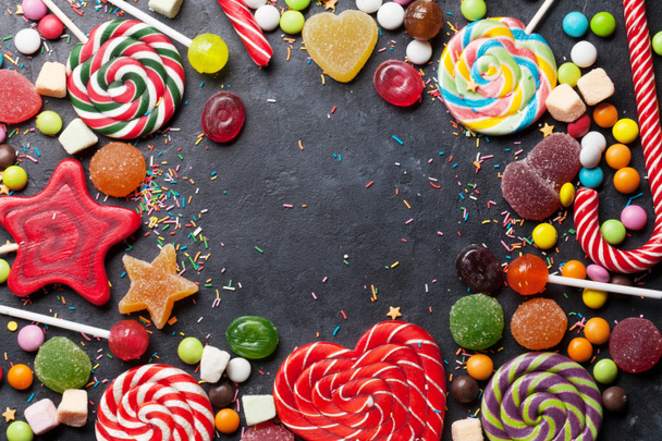 Színes cukorkák. Nyalókák és édességek. A hely részére a Üdvözlet felülnézet - Fotó, kép