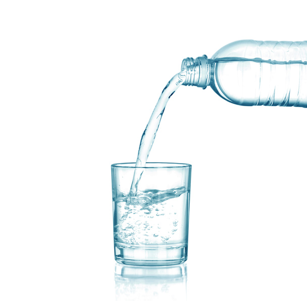 Woda przelewająca się z butelki do szklanki, izolowana na biało - Zdjęcie, obraz