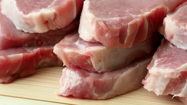 Φέτες φρέσκο νωπό χοιρινό κρέας σε ξύλινη σανίδα - Πλάνα, βίντεο