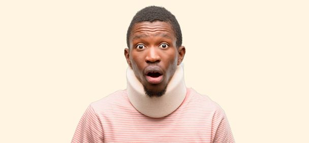Uomo nero africano ferito che indossa il collare spaventato dallo shock, esprimendo panico e paura
 - Foto, immagini