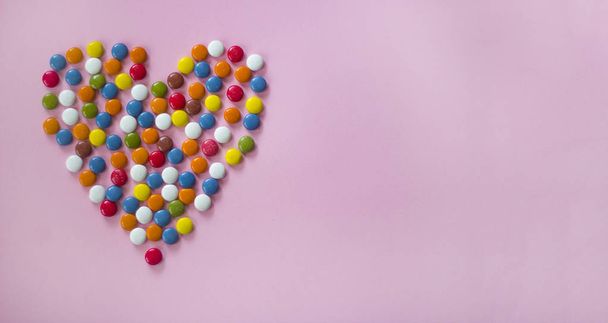 dragees coloridos formando um coração
  - Foto, Imagem