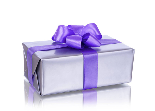 Geschenkdoos met paars lint op witte achtergrond  - Foto, afbeelding