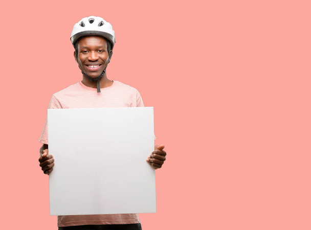 Uomo nero che indossa il casco da bici con banner pubblicitari in bianco, buon poster per annuncio, offerta o annuncio, grande cartellone pubblicitario in carta
 - Foto, immagini