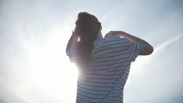 Mujer joven de pelo largo volando en el viento al atardecer
 - Imágenes, Vídeo
