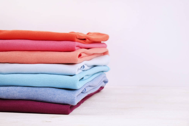 Σύνθεση με διπλωμένα ρούχα, unisex για δύο άνδρα και γυναίκα, διαφορετικό χρώμα & υλικό. Σωρός του πλυντηρίου, στεγνό καθαρό ρουχισμό - Φωτογραφία, εικόνα