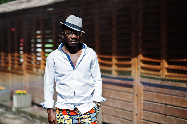 Stylish african american man in white shirt and colored pants wi - Foto, imagen