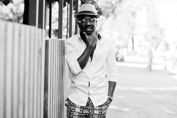 Стильный африканский американец в белой рубашке и цветных брюках с
 - Фото, изображение