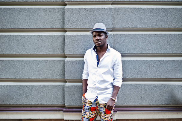 Stylish african american man in white shirt and colored pants wi - Zdjęcie, obraz