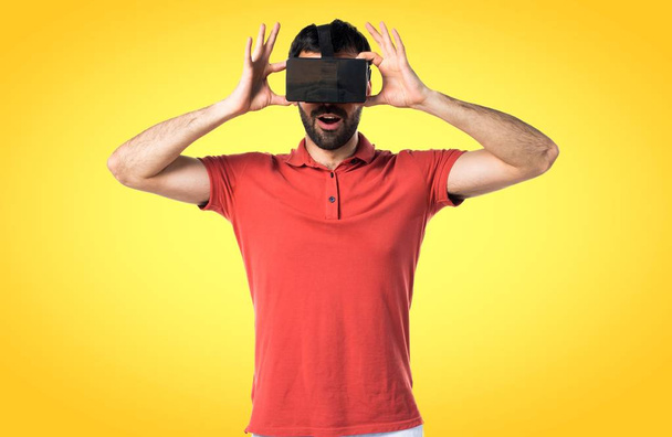 uomo sorpreso utilizzando occhiali VR
 - Foto, immagini