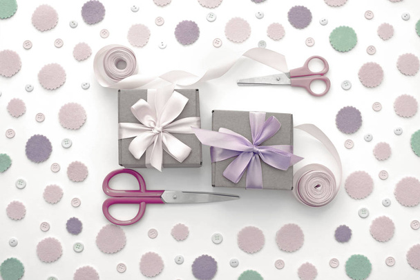 zwei Geschenkboxen auf festlichem Pastell-Konfetti-Hintergrund. - Foto, Bild