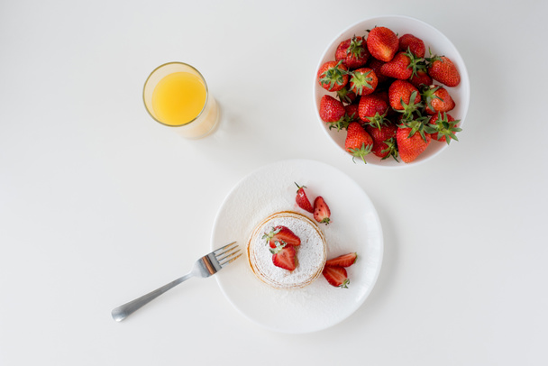 top view of tasty pancakes with strawberries and orange juice - Фото, изображение