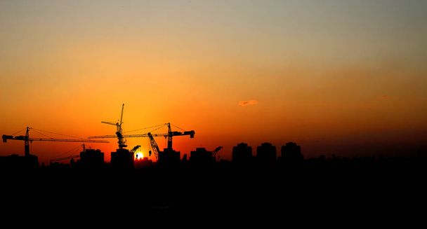 Silhouet kraan bouw bouwen bij zonsondergang - Foto, afbeelding