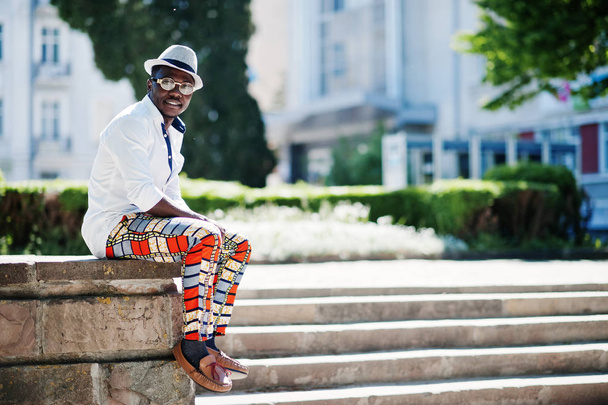 Stylish african american man in white shirt and colored pants wi - Foto, afbeelding