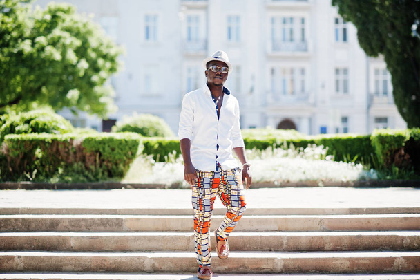 Stylish african american man in white shirt and colored pants wi - 写真・画像