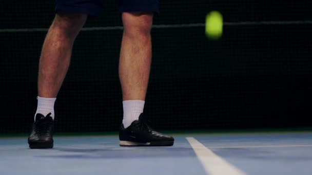 Tennisser houden van de bal en klaar om te serveren. Close-up voeten tennisser voorbereiden om te dienen. Kloppen de bal op de baan en het raken van het racket. - Video